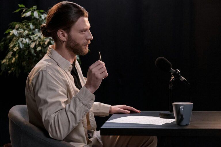 A man recording a podcast in a professional studio environment, engaging with a microphone.